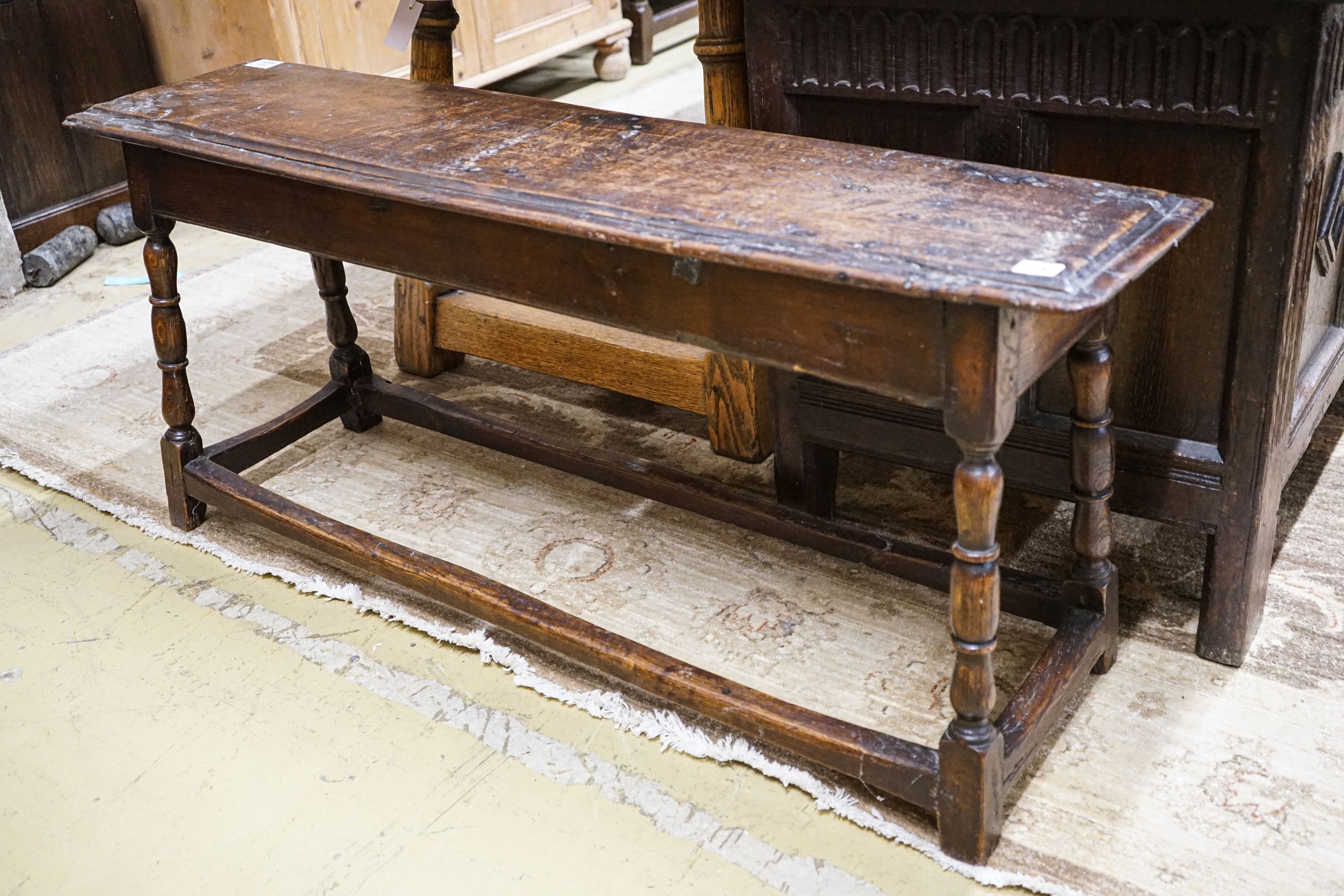 A 17th century style oak long stool, with solid seat on turned legs, length 119cm, depth 28cm, height 53cm